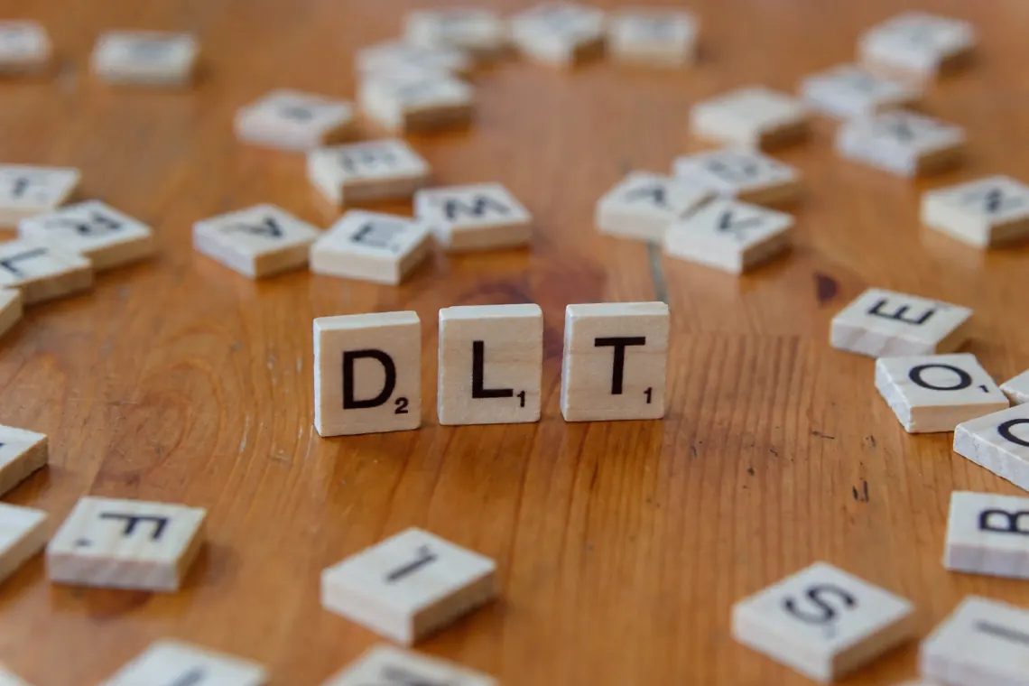 Scrabble-brikker som staver DLT — Din Logopedtjeneste